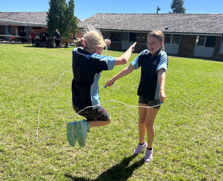 photo of 2 students skipping witha skipping rope together