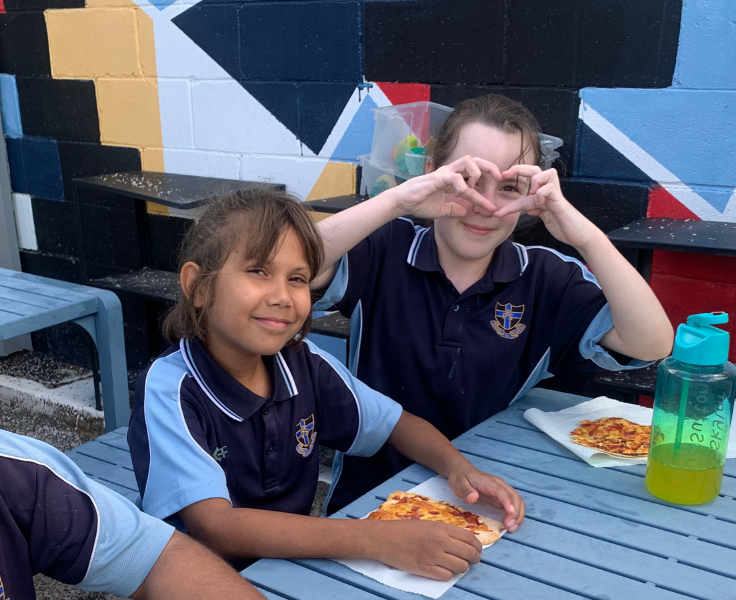 Photo of 2 students enjoying the food they've cooked themselves in the Kitchen