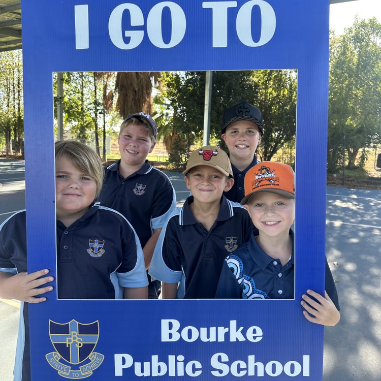 5 stage 3 boys holding a cardboard cut-out that reads