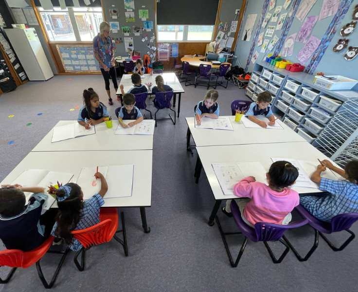 photo of the kinder class doing work in their books