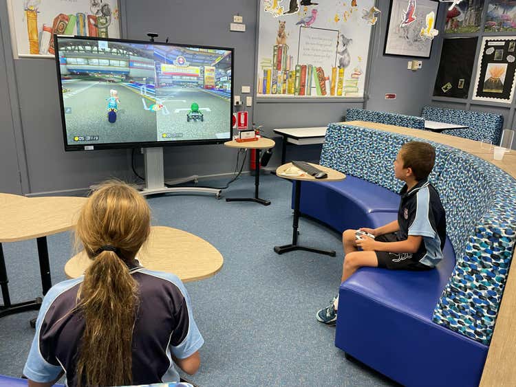 photo of 2 students using one of technology resources at the school