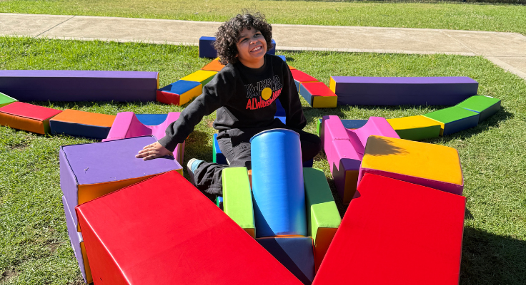 photo of a student sitting inside of a foam block plane