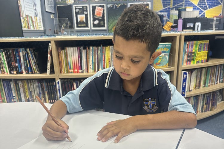 photo of a student drawing a picture in the school library