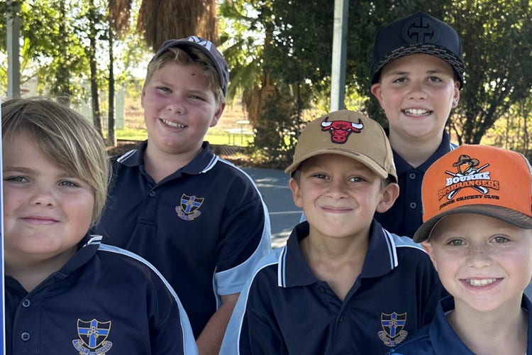 5 stage 3 boys holding a cardboard cut-out that reads
