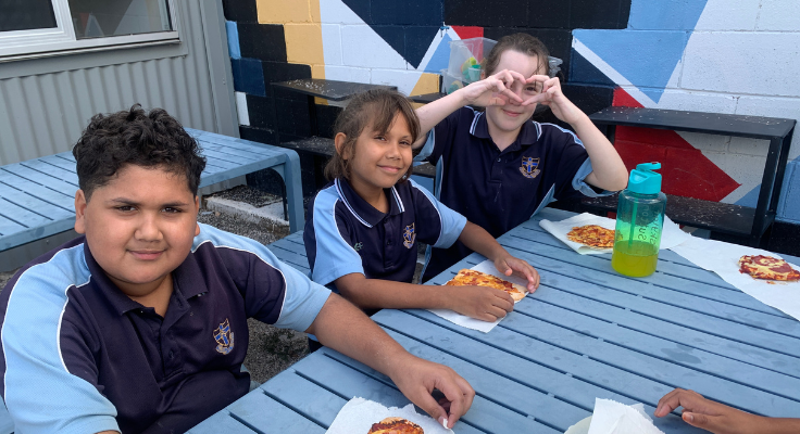 Photo of 3 students enjoying the food they've cooked themselves in the Kitchen